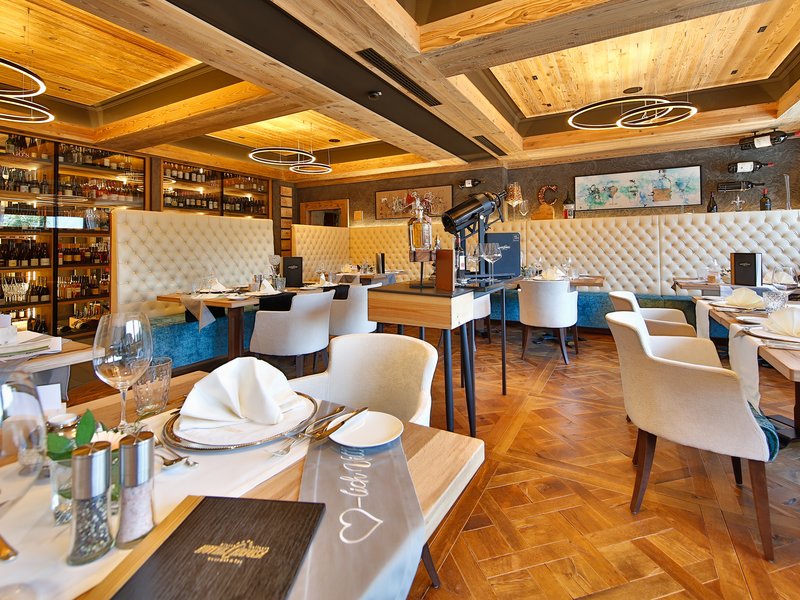 Das Cervosa, Ihr Wellnesshotel mit Verwöhnpension Elegantes Restaurant mit Holzboden, modernem Holzdecke und gemütlichen Sitzplätzen