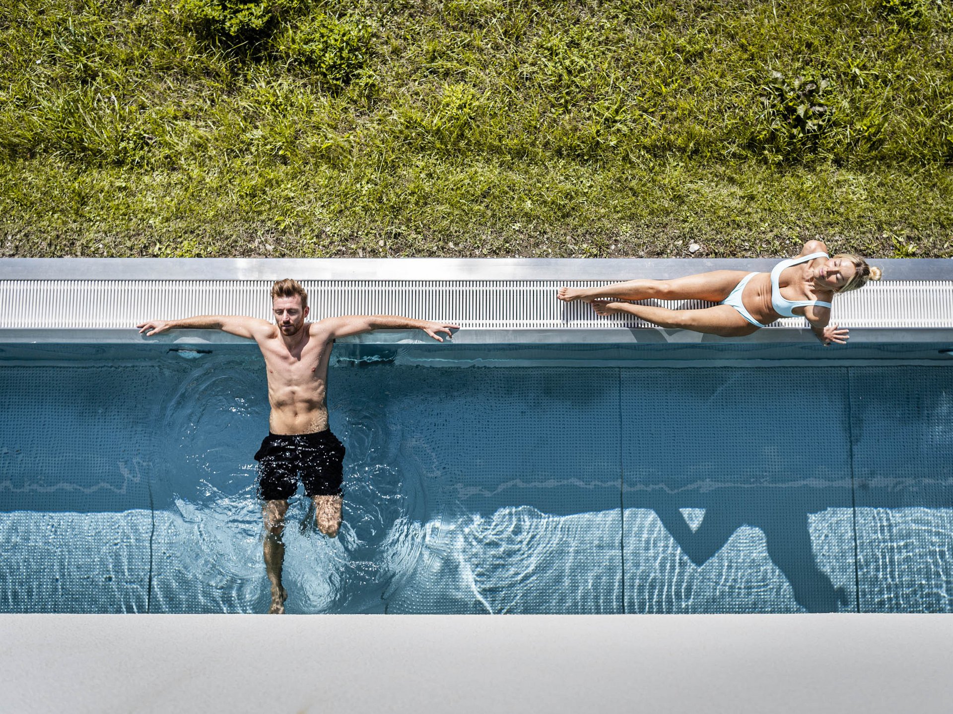 Stay close to nature at Cervosa Man in pool and woman sunbathing on edge beside grass