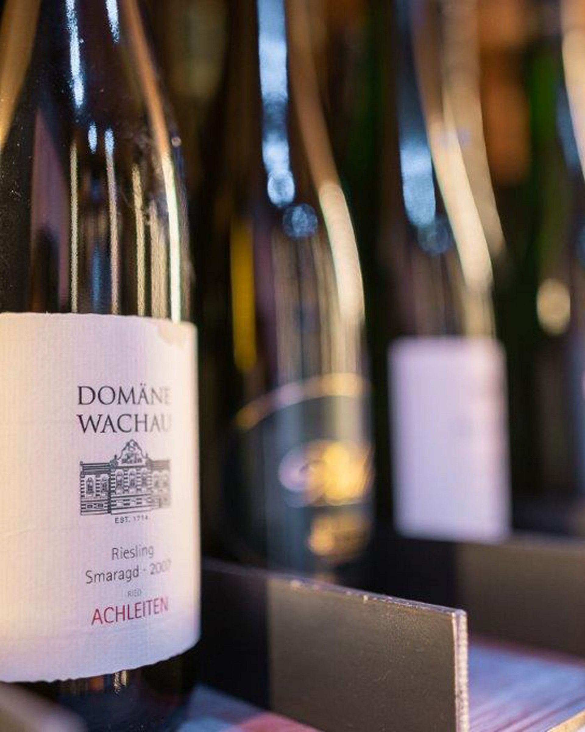 Finest wines and more: wine holiday in Austria at Cervosa Wine bottles on a shelf, focus on Domäne Wachau Riesling Smaragd 2009