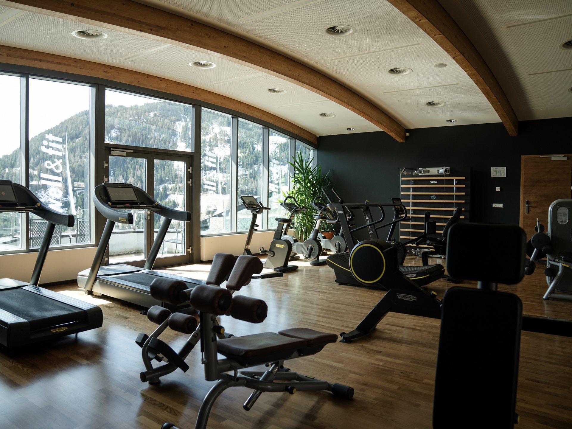 Wohlfühlurlaub im 5-Sterne-Hotel in Serfaus Fitnessraum mit Heimtrainern vor Fenstern mit Bergblick
