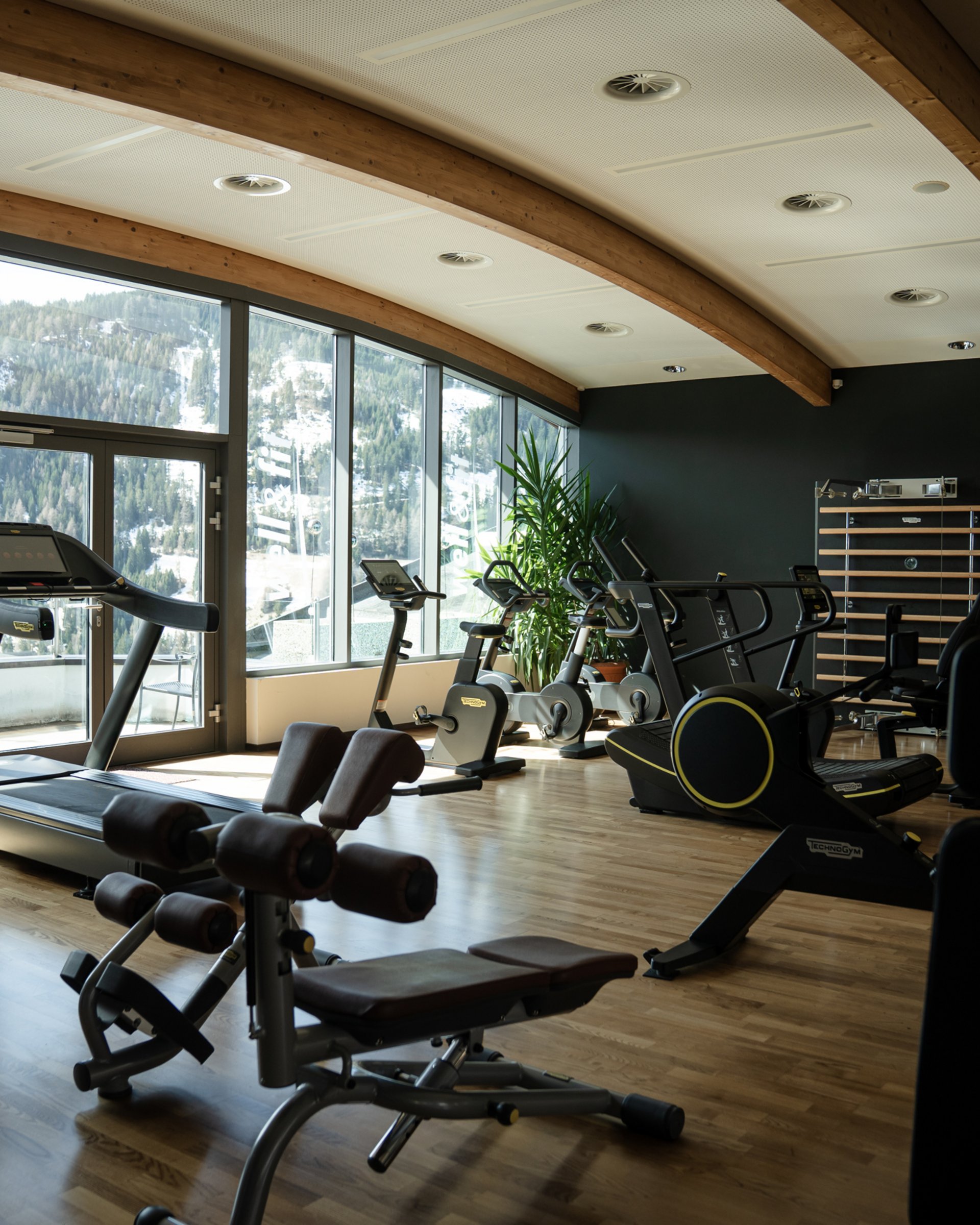 Wohlfühlurlaub im 5-Sterne-Hotel in Serfaus Fitnessraum mit Heimtrainern vor Fenstern mit Bergblick