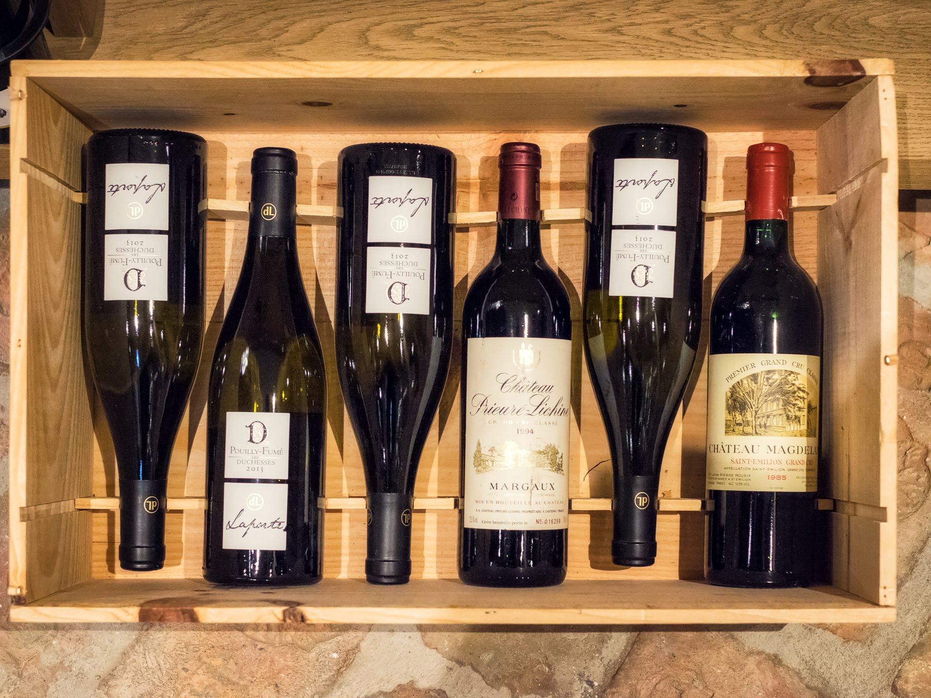 Finest wines and more: wine holiday in Austria at Cervosa Six wine bottles in a wooden crate on a stone floor