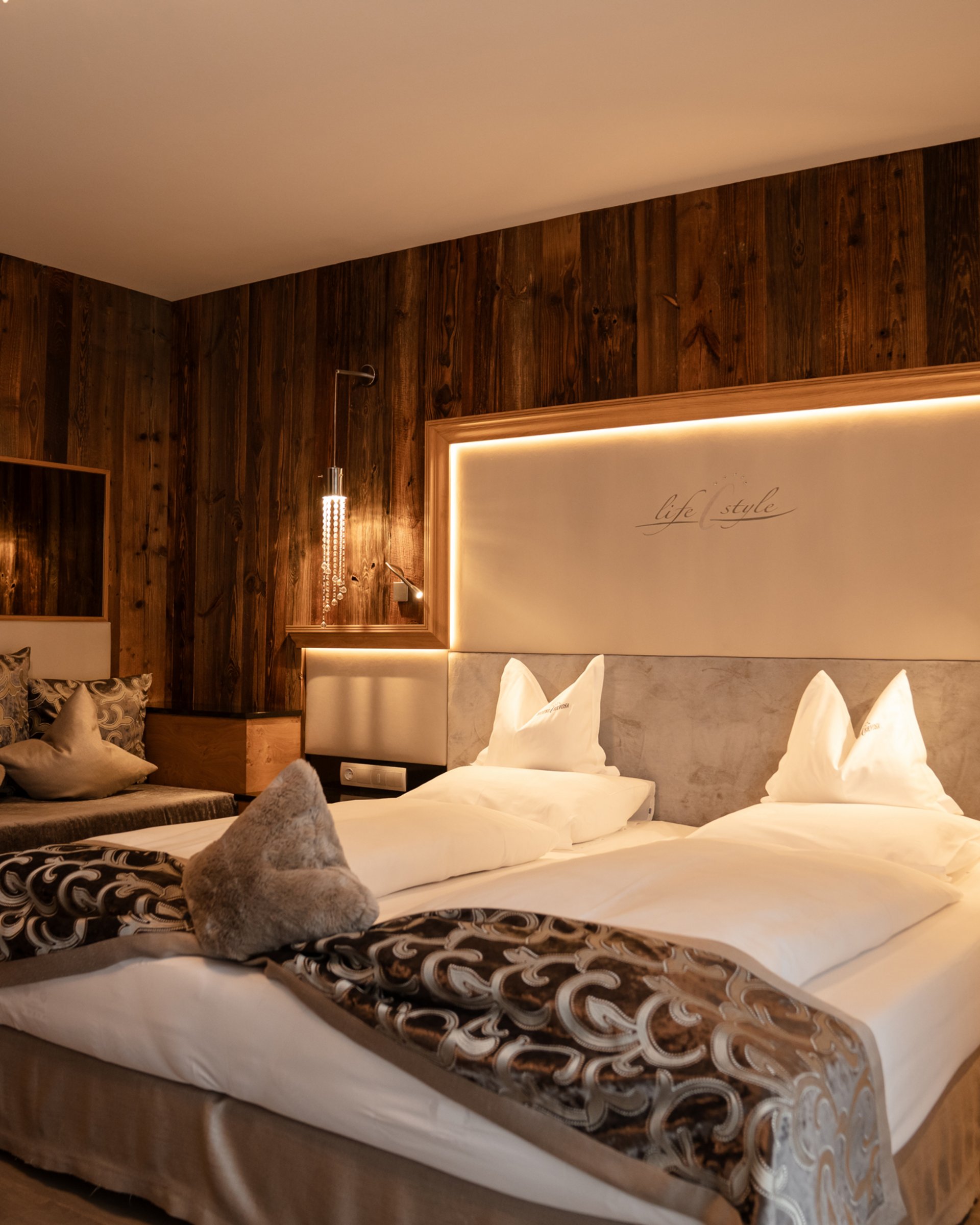 Wohlfühlurlaub im 5-Sterne-Hotel in Serfaus Gemütliches Hotelzimmer mit Holzverkleidung und modernem Dekor