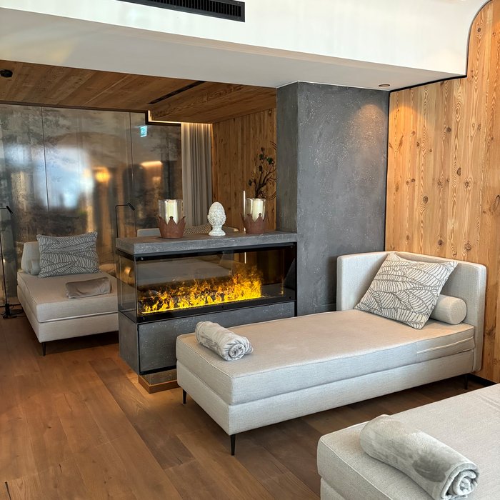 Cervosa – Ihr nachhaltiges Hotel in Österreich Modernes Wohnzimmer mit Kamin, Holzboden und beigen Loungemöbeln