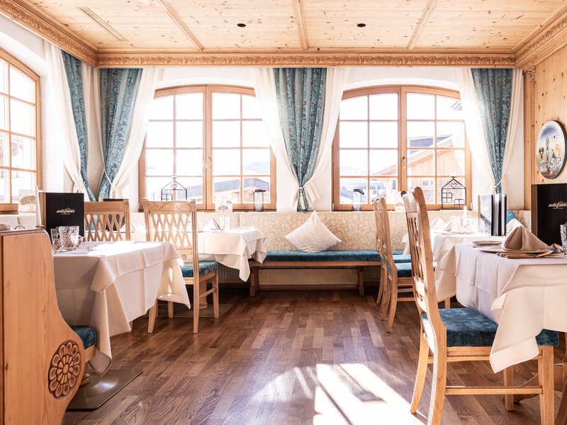 Cervosa, your wellness hotel with pampering board Bright cozy restaurant with wooden furniture and white tablecloths
