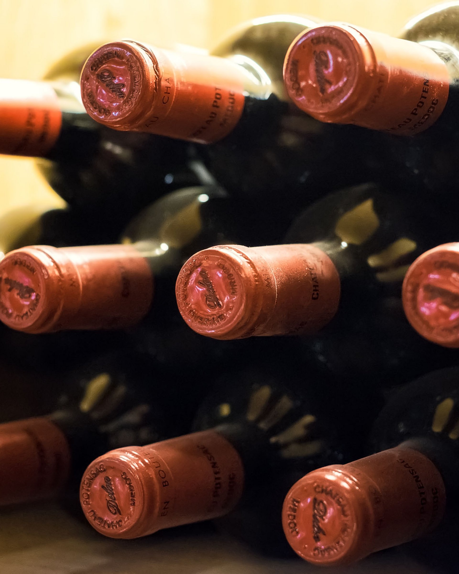 Finest wines and more: wine holiday in Austria at Cervosa Several bottles with red caps stored in a wine cellar rack