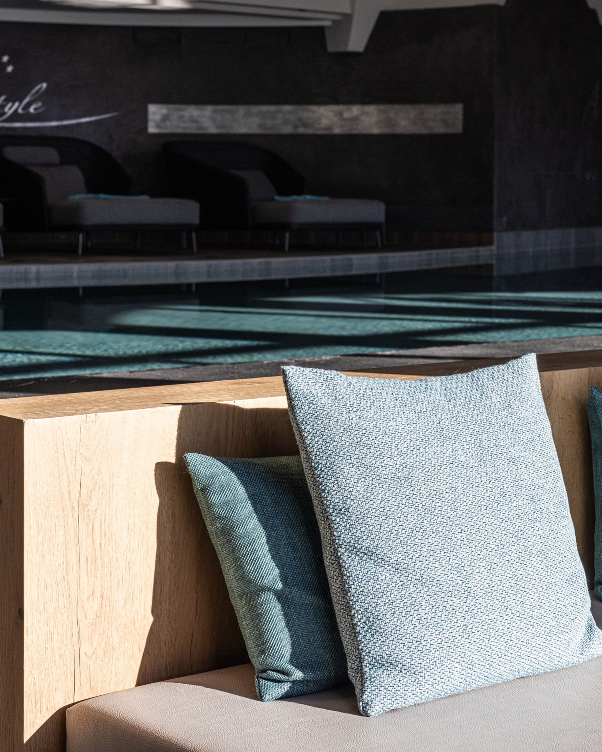 Wohlfühlurlaub im 5-Sterne-Hotel in Serfaus Moderne Lounge mit Kissen vor einem indoor Schwimmbad