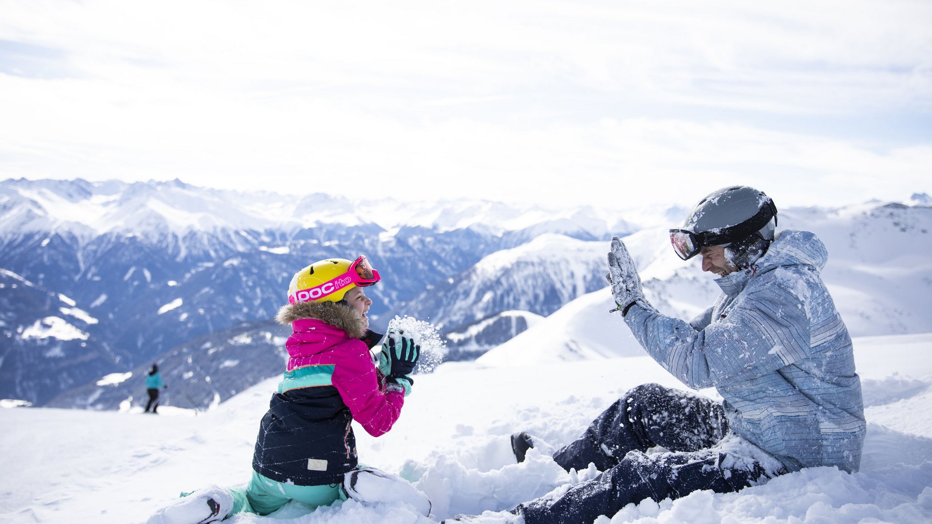 Ligne Mille de luxe facial Child and adult playing in the snow in the mountains on a sunny day