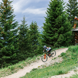Wohlfühlurlaub im 5-Sterne-Hotel in Serfaus Zwei Mountainbiker fahren im Bikepark durch eine bewaldete Berglandschaft